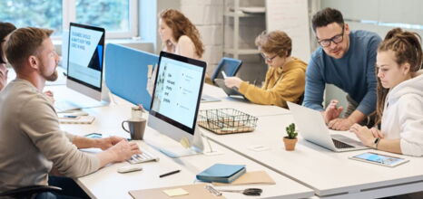 Team working on computers and tablets in a modern office