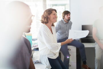 4 people sitting in an office and talking