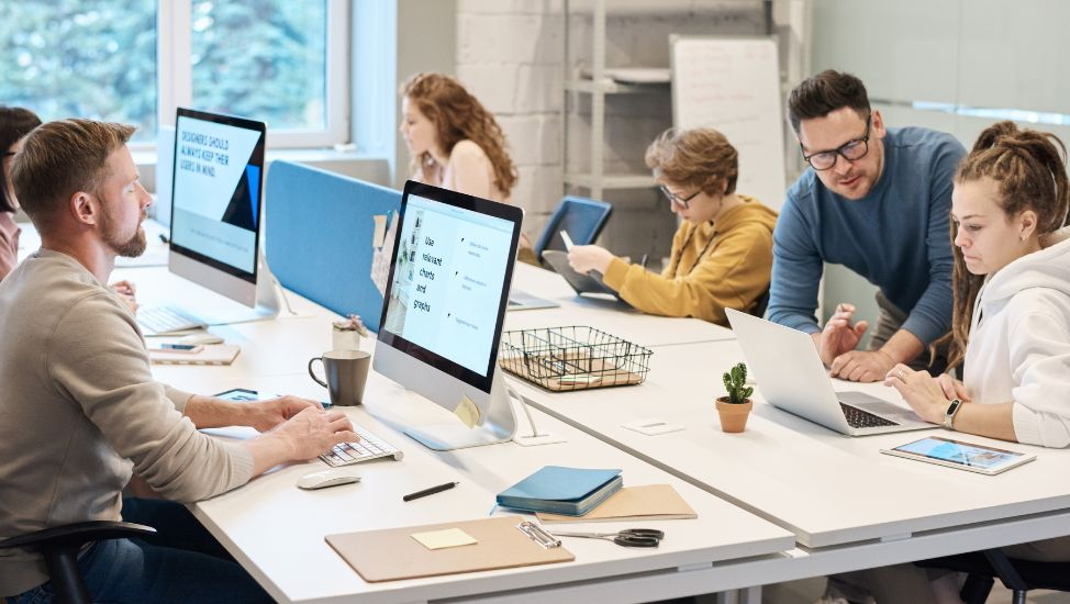 Team working on computers and tablets in a modern office