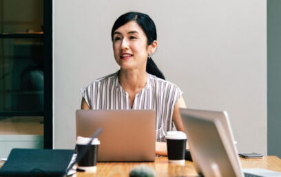 Person sitting in front of a laptop at a conference table